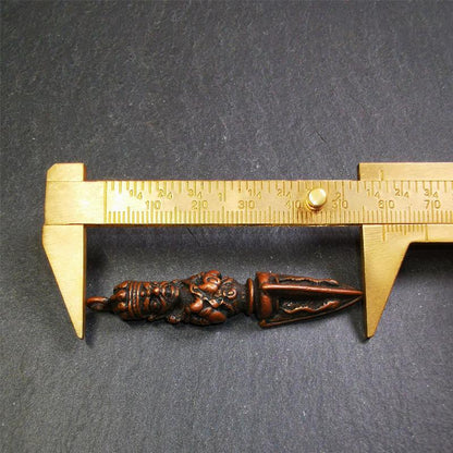 This vintage Phurba pendant was collected from Rega Monastery(Baiyu,Tibet),handmade of copper. It has a statue of Vajrapani on the top and a phurba on the lower part, measuring about 2.36 inches by 0.47 inch.