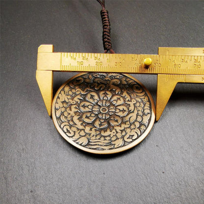 This unique meling amulet is handmade in Baiyu County Tibet,Where is the famous handicraft industry base in Tibetan areas.  It is made of lima brass,2.16 inches diameter,the front center is a very rare mandala flower shape.