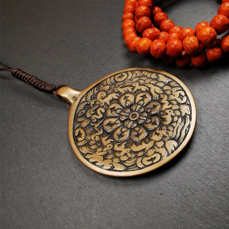 This unique meling amulet is handmade in Baiyu County Tibet,Where is the famous handicraft industry base in Tibetan areas.  It is made of lima brass,2.16 inches diameter,the front center is a very rare mandala flower shape.