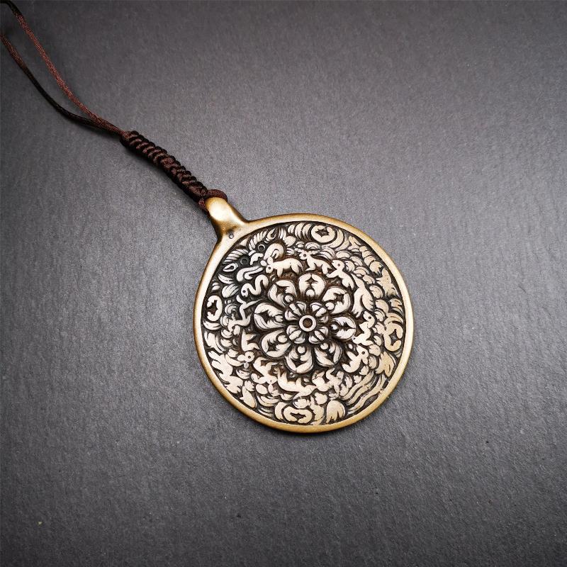 This unique meling amulet is handmade in Baiyu County Tibet,Where is the famous handicraft industry base in Tibetan areas.  It is made of lima brass,2.16 inches diameter,the front center is a very rare mandala flower shape.