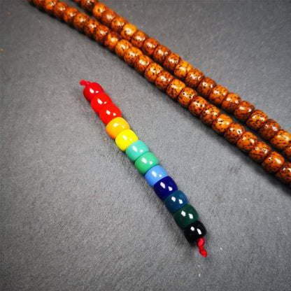 The price is 1 pair of 2 Strings Sherpa Glaze Beads,total 24 beads.(each string 12 beads)  These marker beads were handmade by Tibetan craftsmen and come from Hepo Town, Baiyu County, the birthplace of the famous Tibetan handicrafts. It is made of sherpa glaze,rainbow color,size is 0.31" × 0.24". Fit for 6-8mm mala (The reference in the photo is 8mm lotus seed mala)