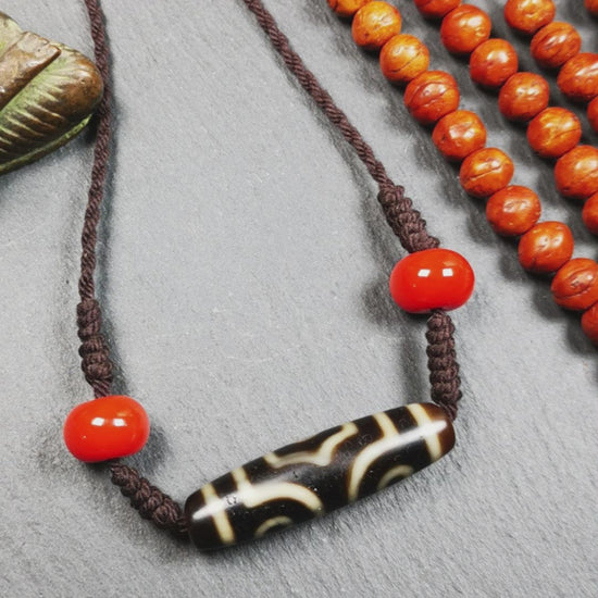 This necklace was hand-woven by Tibetans from Baiyu County, the main bead is a 3 eyed dzi bead, paired with 2 agate beads,about 30 years old. It can be worn not only as a fashionable accessory but also holds cultural and religious significance.